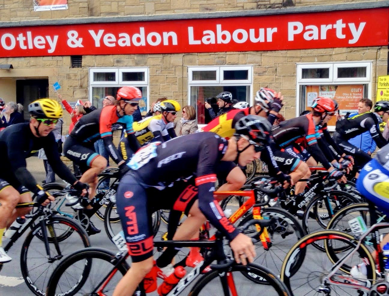 Cyclists racing past the Otley and Yeadon Labour Rooms